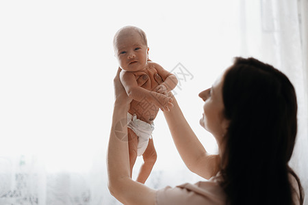 幸福的母亲怀着新生婴儿在她的怀里图片