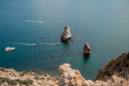 两块岩石从海水中刺出 在松绿海中央 景色洋观 快艇在海上航行 高品质的相片图片