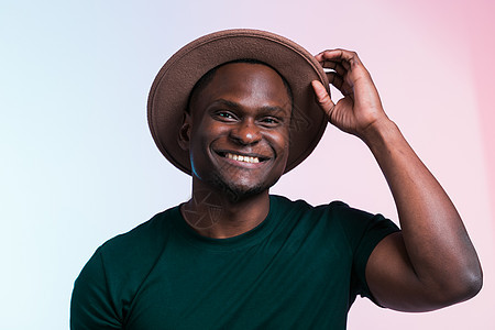笑笑快乐的美国非洲男人 在白色背景上戴着时髦的帽子 喜剧和政党概念电话男性情感派对粉色庆典工作室冒充紫色微笑图片