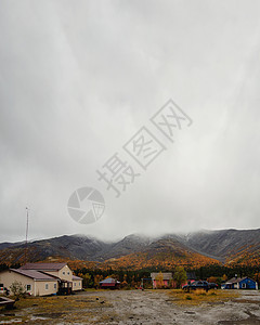 秋天在基比尼KSS基地的灰色秋天 在秋山背景下的房子和汽车图片