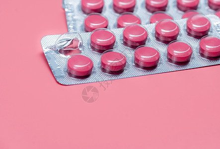 采取药丸概念 在粉红色背景的泡罩包装中的粉红色药丸 处方类药物 医药行业 药丸提醒或药物提醒背景 维生素 矿物质和补充剂图片
