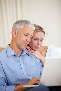 网上聊天 一对已婚夫妇在家里拿着笔记本电脑坐着图片