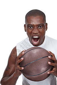 摄影棚拍摄了一位坚定的年轻篮球运动员在打篮球时大喊大叫图片