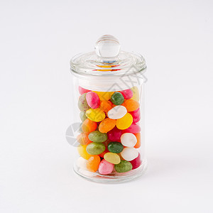 玻璃罐装满糖果和焦糖 盖子特写在白色背景上图片