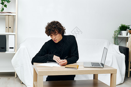 坐在白色沙发在线培训通讯上的家伙笔记本电脑学生职业微笑技术耳机视频电话公寓长椅互联网图片