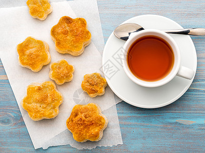 一杯茶和甜糕点的传统早餐 一盘烤饼 一杯茶 木蓝桌上的勺子 俯视 乡村风格图片