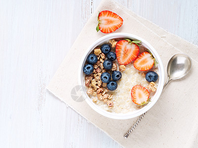含草莓 蓝莓 白木本底的麦片粥 健康早餐 顶端视图稀饭牛奶木头粮食蜂蜜燕麦饮食奶制品乡村浆果图片