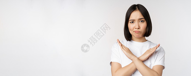 白短袖身穿短衫站在白背景上站立的亚洲韩国妇女肖像 禁止手势 举臂十字牌 穿着短袖圆领汗衫技术广告企业家互联网成人情感女士工作室商业情绪背景