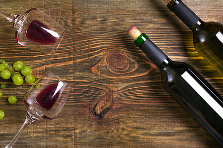 红酒和白酒瓶 葡萄和玻璃杯 放在木制桌边食物美食木板软木瓶子说谎熟食框架饮料眼镜图片