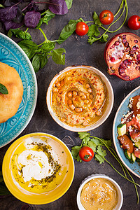 食用中东部素食盘子的餐桌 Hummus Tahini pitta couscous沙拉和含橄榄油的奶油泡水香料菜单草药桌子蓝色环图片