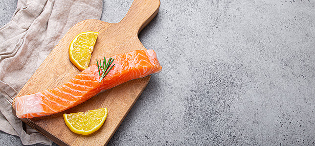 生鲑鱼鱼片 配有柠檬网和木制板上的迷迭香营养柠檬饮食食物木板厨房海鲜菜单石头砧板图片
