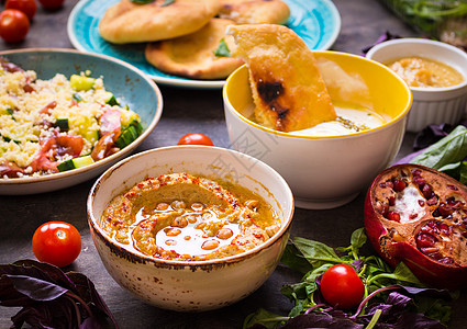食用中东部素食盘子的餐桌 Hummus Tahini pitta couscous沙拉和含橄榄油的奶油泡水餐厅蓝色菜单桌子环境香图片