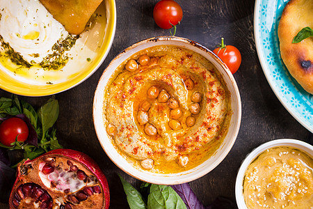 食用中东部素食盘子的餐桌 Hummus Tahini pitta couscous沙拉和含橄榄油的奶油泡水香料辣椒桌子蓝色香菜草图片