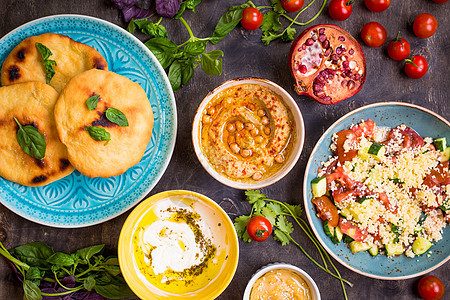 食用中东部素食盘子的餐桌 Hummus Tahini pitta couscous沙拉和含橄榄油的奶油泡水服务桌子菜单派对蓝色辣图片