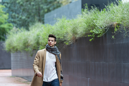 身着冬衣的英俊青年男子在城里行走成人外套游客城市围巾商务头发男性男人人士图片