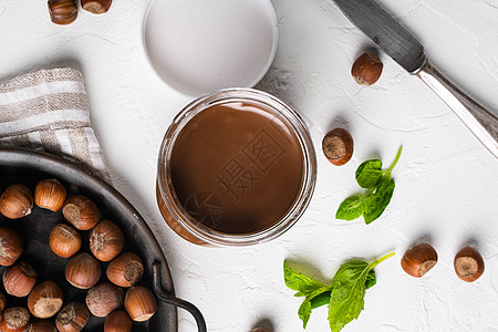 巧克力撒布或甜甜奶油加栗子 在白石桌背景上 顶端的视野平坦图片