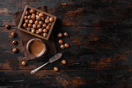 巧克力撒布或酸奶油加栗子 在旧黑色木制桌底的老黑木板背景上 顶层视野平铺 有文字复制空间图片