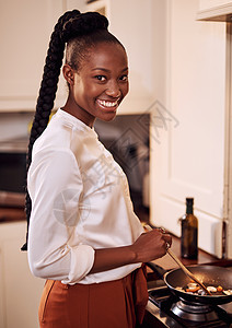 我在做我的最爱 剪裁的肖像画 一个有魅力的年轻女人在家里厨房做饭图片