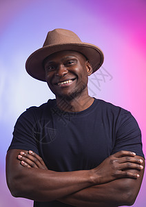 笑笑快乐的美国非洲男人穿着时髦的帽子 在粉色和紫色背景上穿电话工作室冒充拳头情感成人黑色男性派对微笑图片