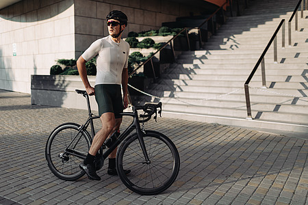 身戴头盔和眼镜的运动员坐在户外自行车上图片