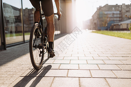 穿着肌肉大腿的近身男子在户外骑自行车图片