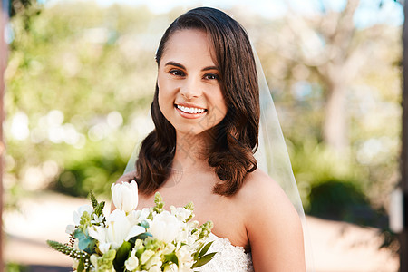 今天我要结婚了 一位美丽的年轻新娘在婚礼当天拿着一束鲜花微笑的裁剪肖像图片