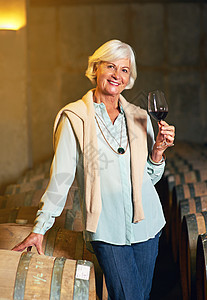 剪裁的一位年长女子的肖像 享受了一点葡萄酒饮料背景图片
