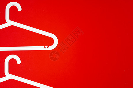 红色纸面背景的挂衣架 最小时尚概念 顶部视图精品金属塑料零售架子衣帽间店铺休闲装销售外套图片