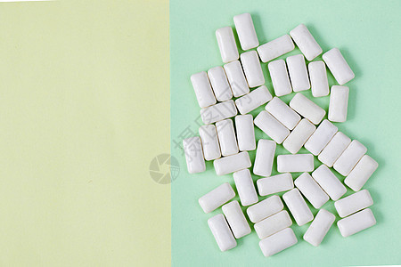 黄色和绿色背景的白咀嚼口香糖软糖口服牙科卫生糖果味道视角药品材料气泡图片