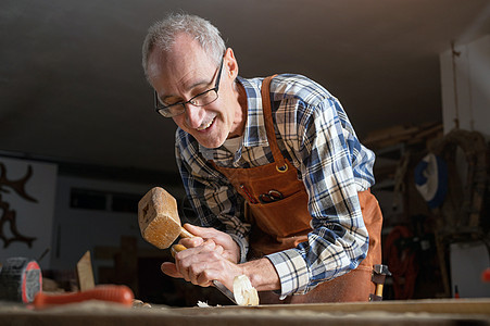 木匠用锤头和铲子雕刻木柴艺术爱好木材手工男人建造木工木头工匠工人图片