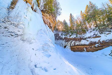 冰雪和冰冻瀑布的雪 在悬崖上与树木图片