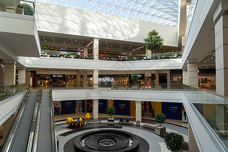 现代大型购物和娱乐综合体的内地 Trinity有一个透明的玻璃屋顶 笑声办公室金属建筑学天花板购物中心民众地面桌子城市中心图片
