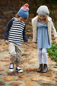 去秋游 两个可爱的孩子在秋天的一天在他们的花园里散步的全长镜头图片