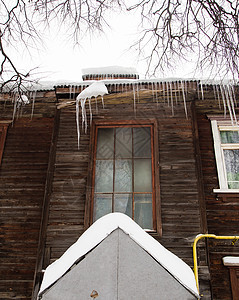 冬季透明的冰柱挂在屋顶的边缘图片