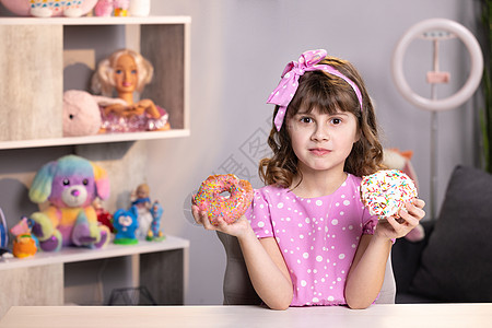 可爱快乐的女学生无法在粉色甜甜圈和黄色新鲜蛋白杏仁饼干之间做出选择 健康的生活方式 糖果 爱吃甜食 正在节食图片