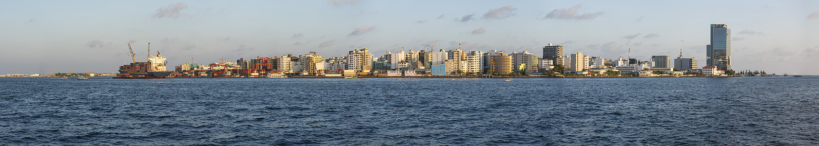 马尔代夫大型岛屿城市马累大岛市的全景三角帆商业天空塔楼集装箱海运货船上层建筑工业海岸图片
