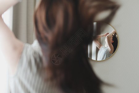 看着镜子照着头发的年轻女人的肖像画乐趣光泽度健康洗发水反射护理卷曲理发师美容院吹风机图片