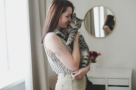 有个年轻女人在家养猫家庭房间乐趣女孩幸福友谊伴侣客厅短发女性图片