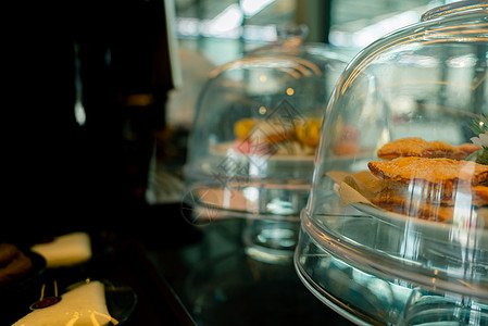在咖啡店或面包店的蛋糕玻璃架上展示带盖圆顶的糕点 蛋糕中的糕点站在柜台上 在餐厅提供自助服务 为服务客户提供糕点和咖啡厅图片