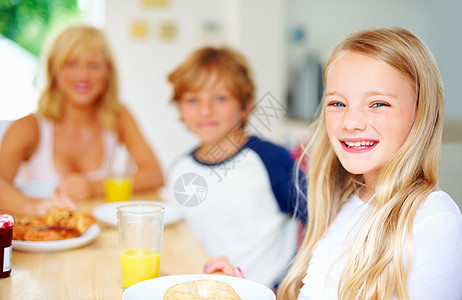 微笑的小女孩和她的家人一起吃早餐 一个微笑的小女孩和她的家人一起吃早餐的画像图片
