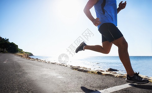 跑步是一种生活方式 从低角度看海洋旁边的选手裁剪风景海滩锻炼成人女性运动员运动装竞技耐力赛图片