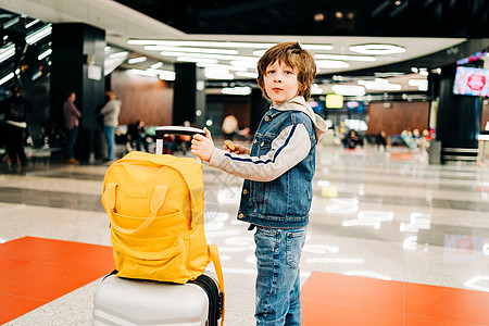 在机场候机站站着的背包男孩儿童 等待飞行 随手提箱旅行 假期概念手提箱孩子们男性运输孩子航班飞机男生行李乐趣图片