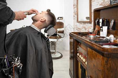专业理发师切割英俊男子胡子胡须造型师发型沙龙店铺剃须刀摄影剃须理发潮人图片