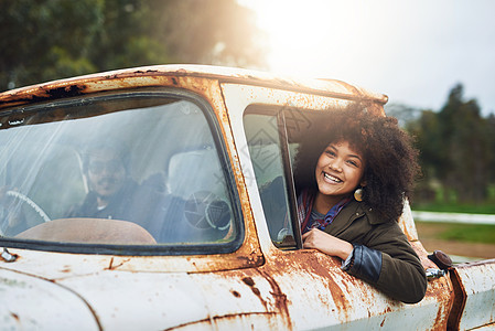 永不停止探险 一个快乐的年轻女人坐在破旧的老卡车里图片
