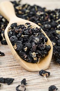黑胡椒莓或黑果汁浆 放在木勺子里草药药品枸杞紫色种子植物静物水果浆果药物图片