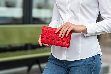 穿白衣服的女孩手里拿着红色钱包店铺金融身体女性黑色商业背景图片
