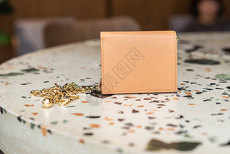 桌上有金链的美丽的皮皮皮钱包图片