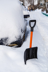 冬天清晨 在雪覆盖的车前放塑料雪铲暴风雪天气风暴漂移运输工具季节汽车城市车辆图片