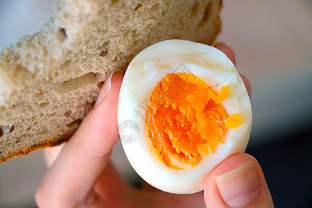 女孩手里拿着煮的鸡蛋和面包 一个快速而健康的零食图片