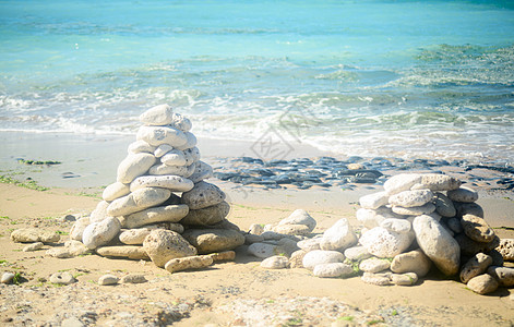 海滩上的石头堆团体闲暇旅游卵石精神治疗温泉平衡石头冥想图片